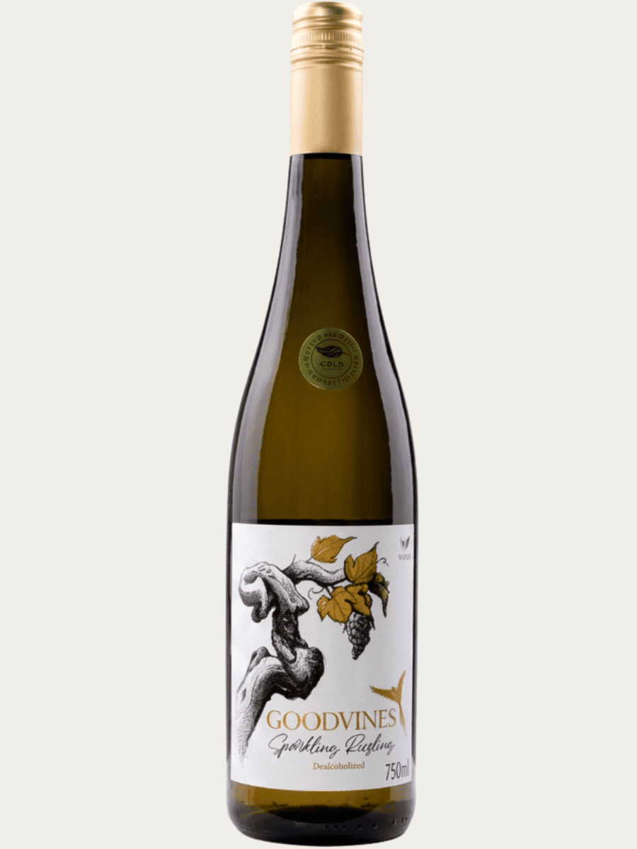 Bezalkoholowe wino musujące Goodvines Sparkling Riesling w szklanej butelce zaprezentowane obok złotego i srebrnego medalu