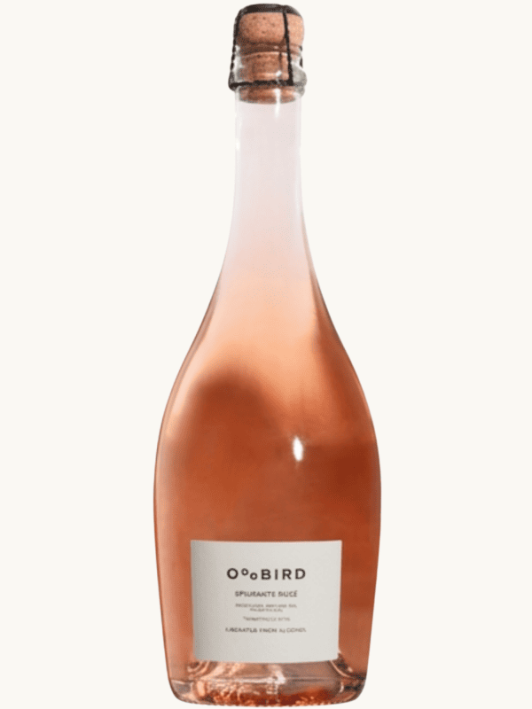 Bezalkoholowe różowe wino musujące Oddbird Sparkling Rosé w eleganckiej, przezroczystej butelce z klasycznym korkiem.